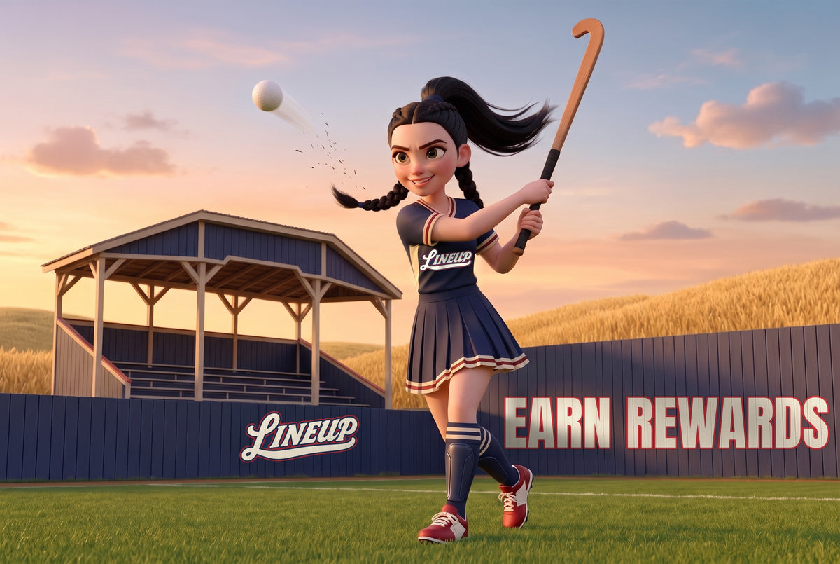 A high school girls field hockey player at the follow through of a hit, shot from a low camera with her stick high and the ball flying toward the upper left, the navy plank wall and covered grandstand of a golden hour field behind her